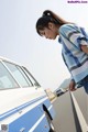 A woman standing next to a blue and white van.