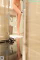 A woman standing in a bathroom next to a shower.