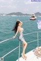 A woman in a blue dress standing on a boat.