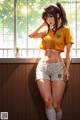 A woman in a yellow shirt and white shorts leaning against a window.